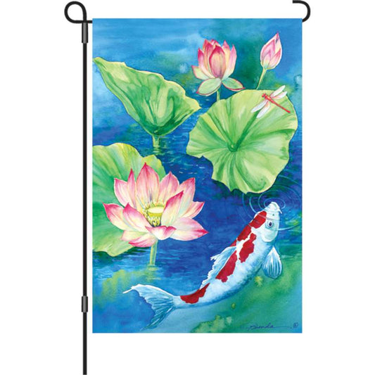 Decorative garden flag with a koi fish and lotus design in front of a pond with real koi fish.