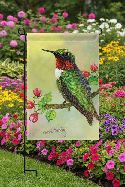 Decorative garden flag with a colorful hummingbird and flowers on a green background